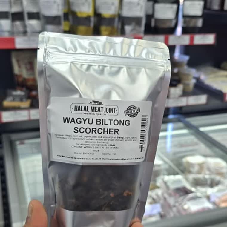 A pouch of Halal Meat Joint Wagyu Biltong Scorcher held in front of the counter